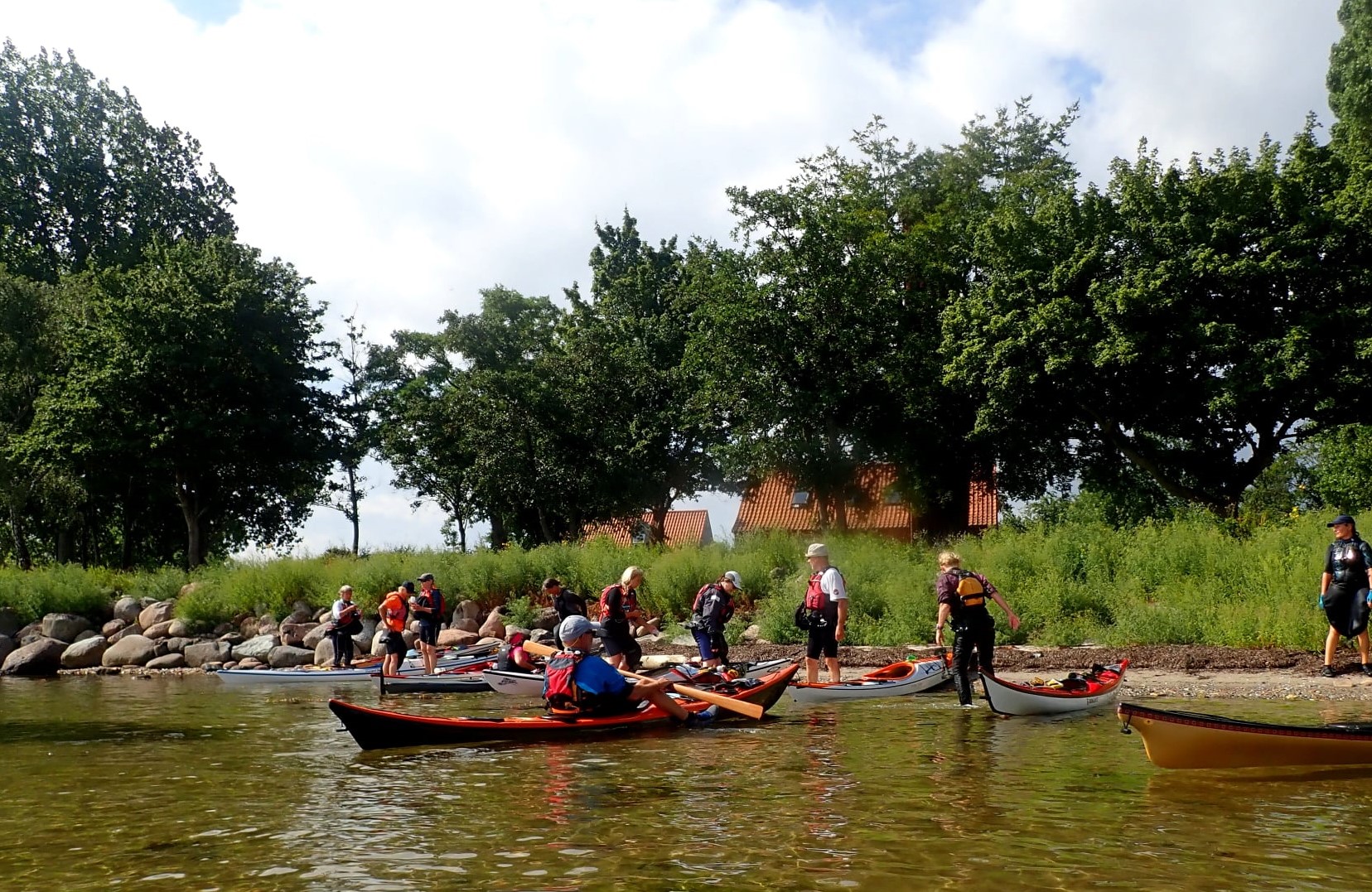 Jane Svejdal : større selskab af personer i og ved havkajakker